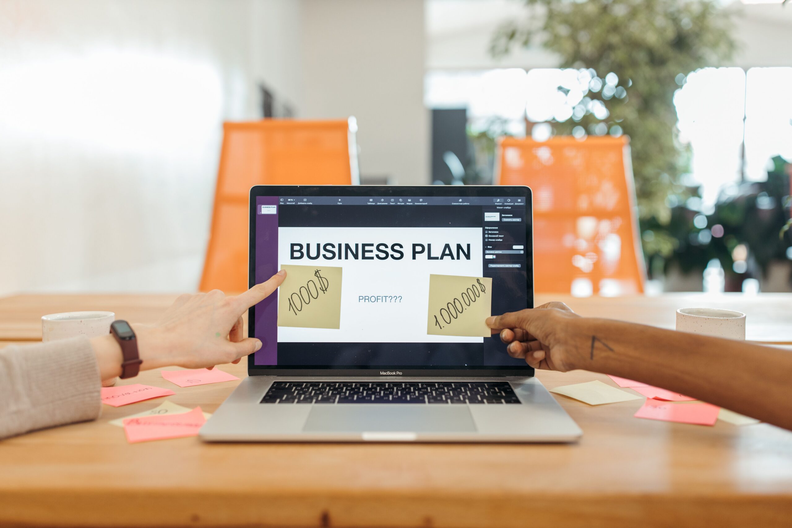 Business coach and small business owner reviewing positioning notes and a business plan