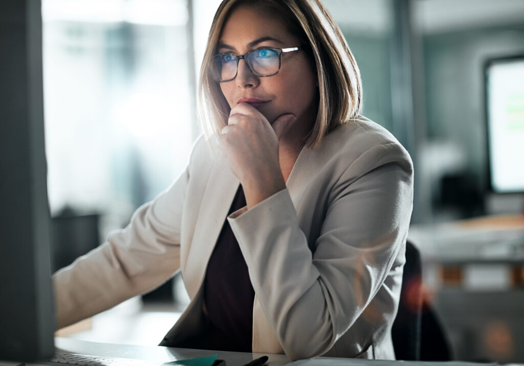 Small business owner considering a difficult business decision at her computer