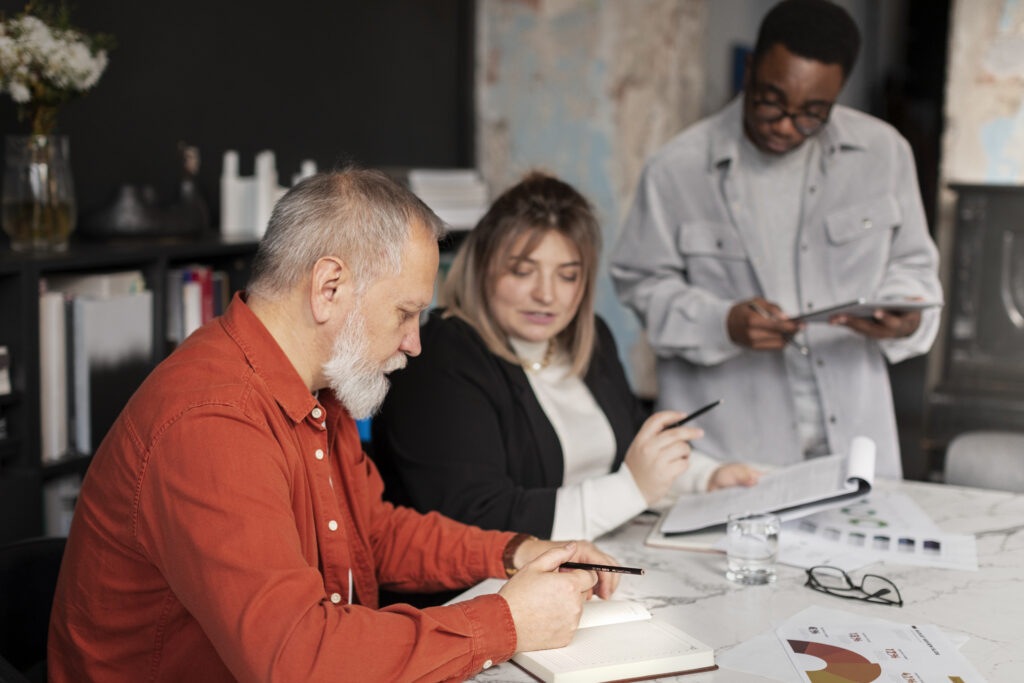 People meeting, discussing, sharing ideas, and studying concepts during a small business coaching course that highlights business coach training, coaching skills for business advisors, and a coach approach for consultants.