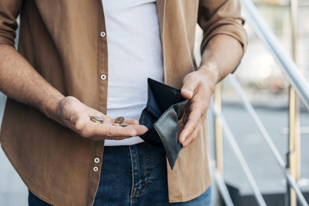 Business owner holding an almost empty wallet, representing tight cash flow